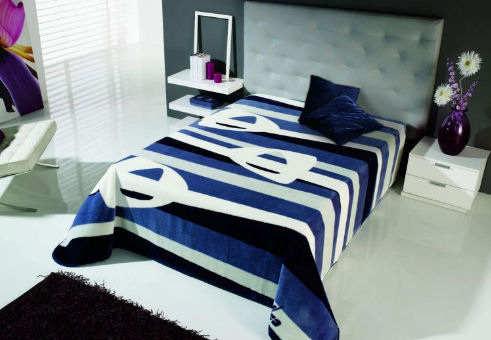 Přikrývka čalouněné postele s modrými pruhy